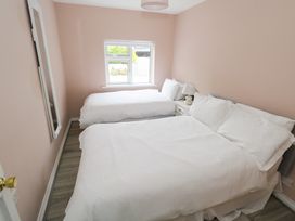 A bedroom with two beds and a window at Churchfield House in Moygownagh near Crossmolina, County Mayo