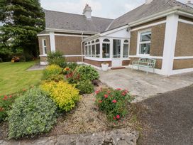 A house with a conservatory and flower beds at Churchfield House Moygownagh near Crossmolina, County Mayo