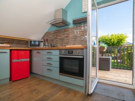A kitchen with red refrigerator and sliding door at Garden View Apartment in Kingsbridge
