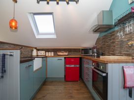 A kitchen with a red refrigerator and various appliances at Garden View Apartment Kingsbridge