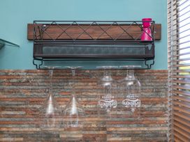 A kitchen with glass rack and hanging wine glasses at Garden View Apartment in Kingsbridge