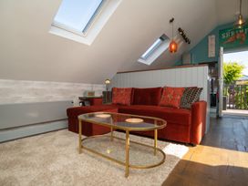 A living room with a red sofa and coffee table at Garden View Apartment in Kingsbridge