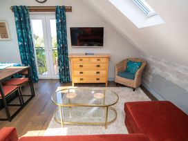 A living room with a television and a dining table at Garden View Apartment in Kingsbridge