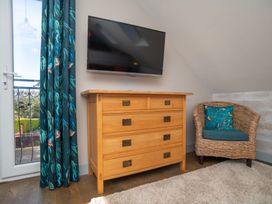 A bedroom with a dresser and TV at Garden View Apartment in Kingsbridge