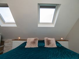 A bedroom with a bed and windows at Garden View Apartment in Kingsbridge