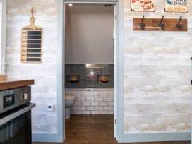 A kitchen with a view of a bathroom doorway at Garden View Apartment in Kingsbridge