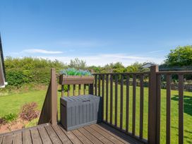 A deck with a storage box and garden at Garden View Apartment in Kingsbridge