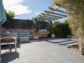 A patio area with outdoor seating and a swing seat at Garden View Apartment in Kingsbridge