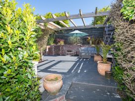 A garden with a patio and a couch under a pergola at Garden View Apartment in Kingsbridge