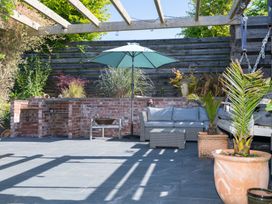 A garden area with an outdoor sofa and umbrella at Garden View Apartment in Kingsbridge