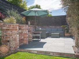 A garden area with a sofa and umbrella at Garden View Apartment in Kingsbridge