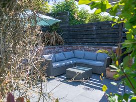 A garden with a couch and coffee table at Garden View Apartment in Kingsbridge