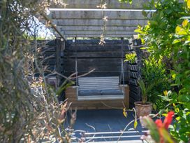 A swing seat with cushions in a garden area at Garden View Apartment Kingsbridge
