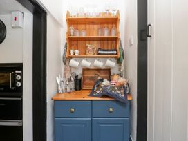 A kitchen area with a cupboard and shelf at Avonmede in Tewkesbury