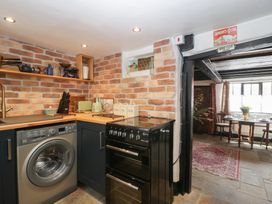 A kitchen with appliances and shelves at Avonmede in Tewkesbury