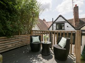 A deck area with chairs and a table at Avonmede in Tewkesbury