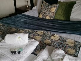 A bedroom with blankets and towels at Avonmede in Tewkesbury