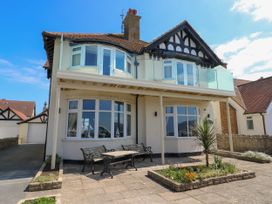 A two-story house with bay windows a balcony benches and a small garden in front at Westbourne in Llandudno