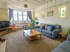 A living room with a sofa set coffee table tv and bay window at Westbourne in Llandudno