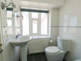 A bathroom with a pedestal sink a toilet a window and a radiator at Westbourne in Llandudno