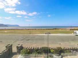 A view of a coastal road with a grassy area and sea beyond at Westbourne in Llandudno