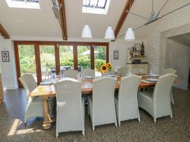 A dining room with a large table and sliding doors at Clynnog House in Dwyran near Newborough