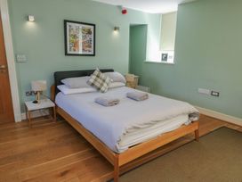 A bedroom with a bed and bedside table at Clynnog House Dwyran near Newborough