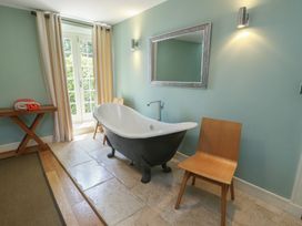 A bathroom with a bathtub and towels at Clynnog House in Dwyran near Newborough