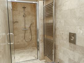 A bathroom with a shower and towel radiator at Clynnog House Dwyran near Newborough