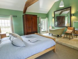 A bedroom with a bed and bathtub at Clynnog House Dwyran near Newborough