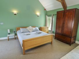 A bedroom with a bed and wardrobe at Clynnog House in Dwyran near Newborough