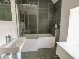 A bathroom with a bathtub and shower at Clynnog House in Dwyran near Newborough