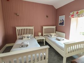 A bedroom with two single beds and a window at Clynnog House Dwyran near Newborough