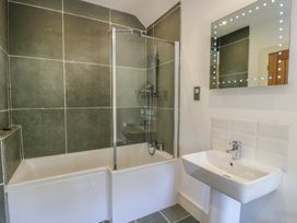 A bathroom with a bathtub and sink at Clynnog House in Dwyran near Newborough