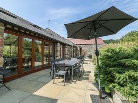 An outdoor patio area with table and chairs at Clynnog House Dwyran near Newborough