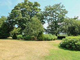A garden with trees and bushes at Clynnog House in Dwyran near Newborough