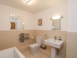 A bathroom with a sink, toilet, and bath at Sail Away, 17 Union Mill in Whitby