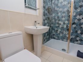 A bathroom with a toilet, wash basin, and shower at Sail Away, 17 Union Mill, Whitby