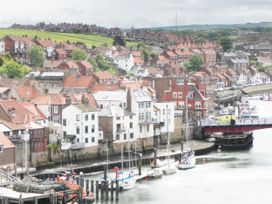 A view of a harbour with boats and houses at Sail Away, 17 Union Mill in Whitby