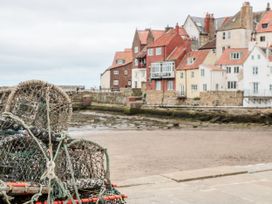 A view of fishing nets and buildings by the shore at Sail Away, 17 Union Mill in Whitby
