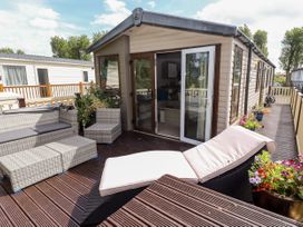 An outdoor deck area with wicker furniture and plants outside a mobile home at 19 The Brambles in Humberston Lincolnshire