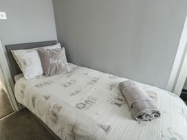A bedroom with a single bed and towel at Glasfryn in Holyhead