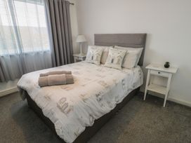 A bedroom with a bed and nightstand at Glasfryn in Holyhead