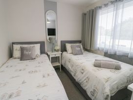 A bedroom with two single beds and a bedside table at Glasfryn in Holyhead