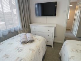 A bedroom with two beds and a television at Glasfryn Holyhead