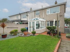 A garden with a conservatory and plants at Glasfryn Holyhead