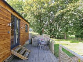 An outdoor area with a wooden cabin and table at Stag Lodge Pod Llanfair Caereinion