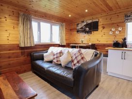 A living room with a sofa and table at Stag Lodge Pod Llanfair Caereinion