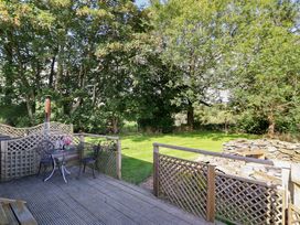 An outdoor area with a table and chairs on a deck at Stag Lodge Pod Llanfair Caereinion