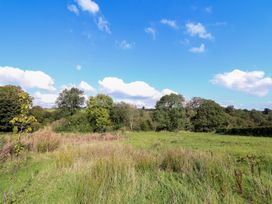A field with trees and clouds at Stag Lodge Pod Llanfair Caereinion
